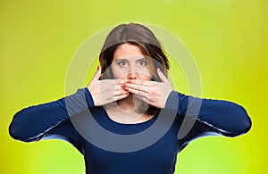 Woman covering closed mouth. Speak no evil concept