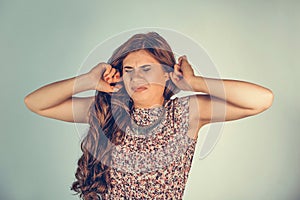 Woman covering ears shouting unhappy