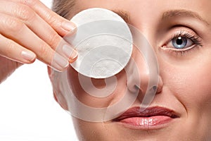 Woman covering eye with cotton pad