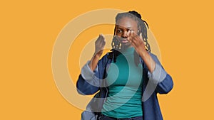 Woman covering eyes, ears and mouth with hands, studio background