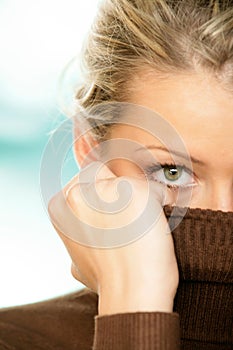 Woman covering face with turtleneck