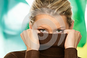 Woman covering face with turtleneck