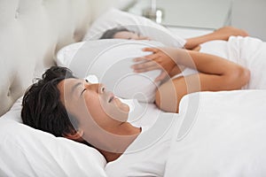 Woman covering her ears as partner is snoring loudly