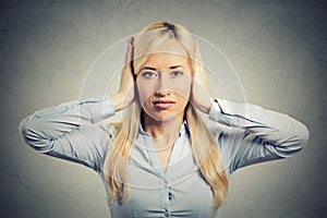 Woman covering her ears avoiding unpleasant rude situation photo