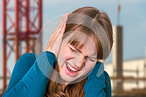 Woman covering her ears to protect from loud noise