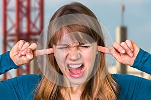 Woman covering her ears to protect from loud noise