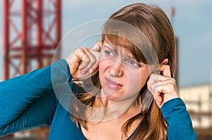 Woman covering her ears to protect from loud noise