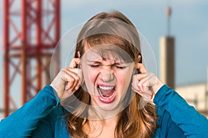 Woman covering her ears to protect from loud noise