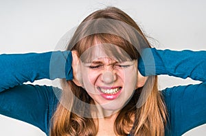 Woman covering her ears to protect from loud noise