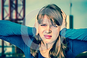 Woman covering her ears to protect from loud noise