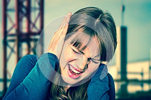 Woman covering her ears to protect from loud noise