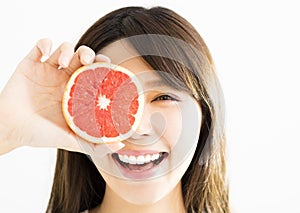 Woman covering her eye with grapefruit