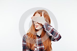 Woman covering her eyes and showing tongue photo