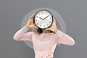 Woman covering her face with big watch