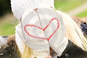 Woman covering her face with winter gloves