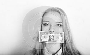 Woman covering her mouth with a dollar banknote as symbol of bribery, cheating, financia and political manipulation