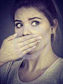 Woman covering her mouth with hand