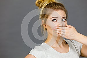 Woman covering her mouth with hand