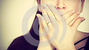 Woman covering her mouth with hand