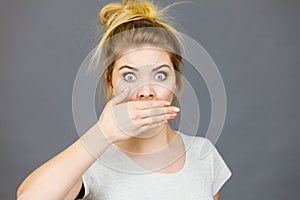 Woman covering her mouth with hand