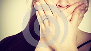 Woman covering her mouth with hand