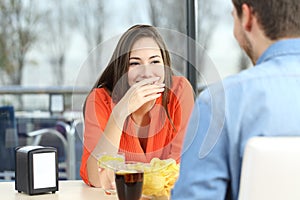 Woman covering her mouth to hide smile or breath photo