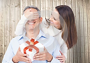 Woman covering mans eyes while gifting
