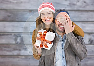 Woman covering mans eyes while gifting