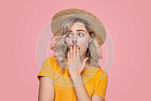 Woman covering mouth and looking away