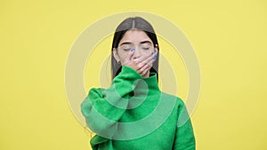 Woman Covering Mouth And Shaking Head In Rejection Over Yellow Background