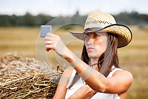Woman in cowboy hat looking at the mirror.