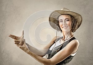 Woman in cowboy hat, making gesture with hands pretending gun