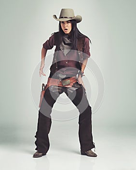 Woman, cowgirl and portrait in studio with weapon or western costume on white background, revolver or outlaw. Female