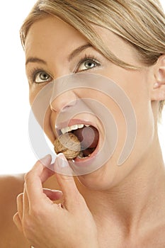 Woman cracking walnut with her teeth