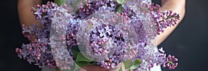 A woman cradles a sumptuous bouquet of lilacs