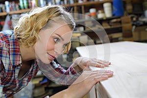 Woman craftsperson working on workbench in workshop