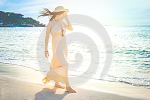 Woman in a cream dress is walking, enjoying the beautiful sunset