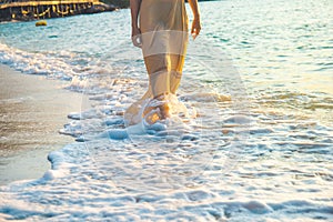 Woman in a cream dress is walking, enjoying the beautiful sunset