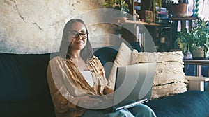 Woman, credit card and computer on sofa for online shopping, e commerce and fintech payment at home. Portrait of person