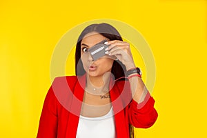 Woman with credit card covering eye posing with puckered lips