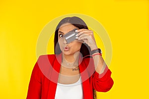 Woman with credit card covering eye posing with puckered lips photo