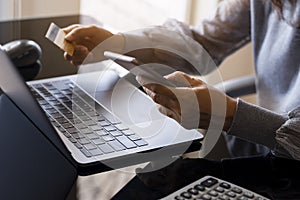 woman hands holding credit card and using mobile smart phone for online shopping and payment a Mobile banking, ecommerce concept.