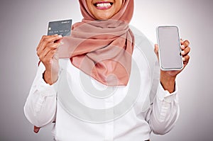 Woman, credit card and phone screen for online shopping, muslim fashion marketing and e commerce in studio. Islamic