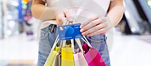 Woman with credit card and shopping bags, closeup