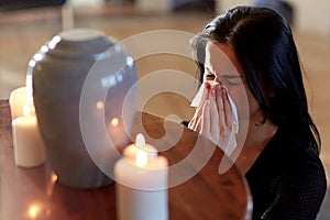 Woman with cremation urn at funeral in church