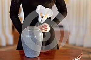 Woman with cremation urn at funeral in church