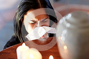 Woman with cremation urn at funeral in church