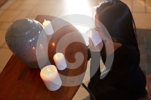 Woman with cremation urn at funeral in church