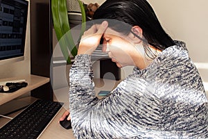 Woman cries at the computer, crisis