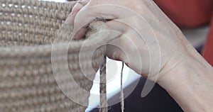 The woman is crocheting from environmentally friendly materials. Jute fiber for home decor. Home hobby of weaving thick-walled rop